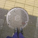 Kyoto manhole cover with a shuriken design at the center.
